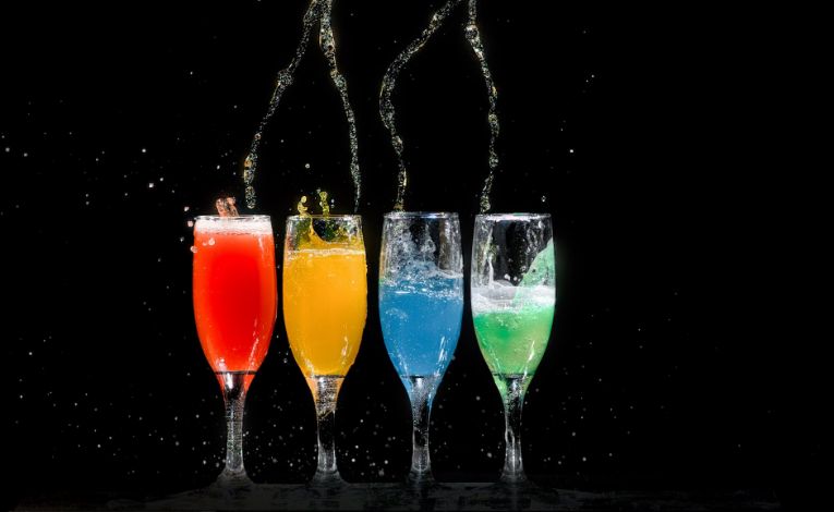 four glasses of colorful drinks